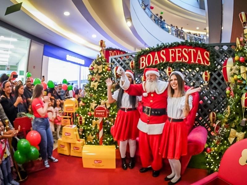 Papai Noel brasileiro em um shopping, tirando fotos com crianças durante o Natal.